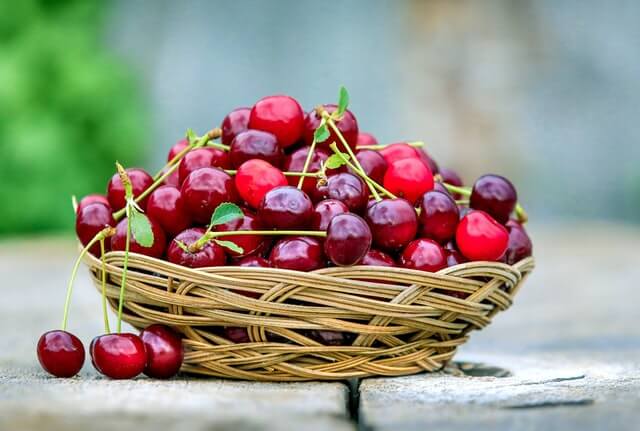 red cherries inside the fruit basket
